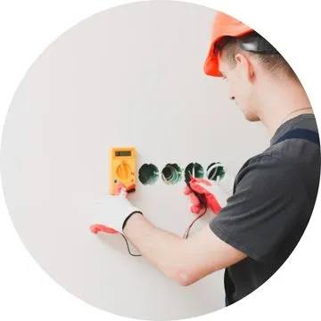 Eletricista realizando atendimento elétrico 24 horas na cidade, solucionando curto-circuito conforme normas NR10 e ABNT NBR 5410.